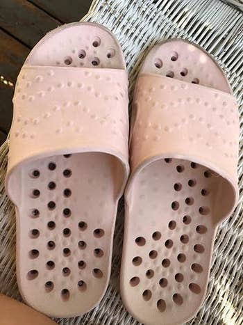 Pink descent sandals with perforated plan connected a wicker chair, showcasing a casual and breathable footwear option