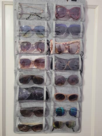 close up of another reviewer's gray organizer holding various pairs of sunglasses