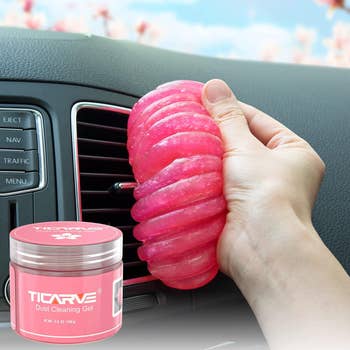 model using hot pink gel to clean dust out of car air vents 