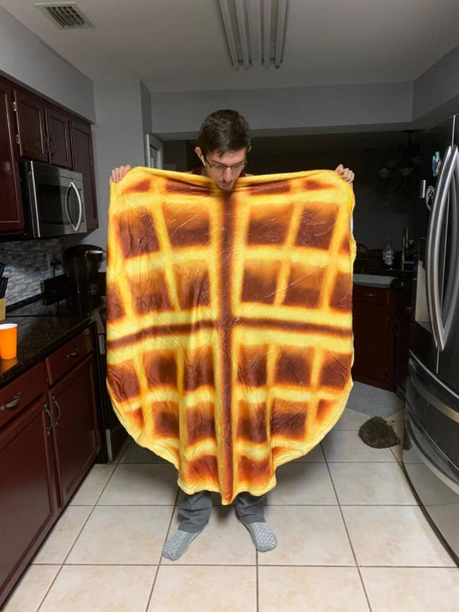 a reviewer holding the waffle blanket open