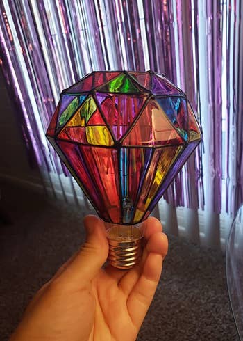 reviewer holding up the stained glass lightbulb