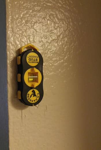 a stud finder stuck to a wall