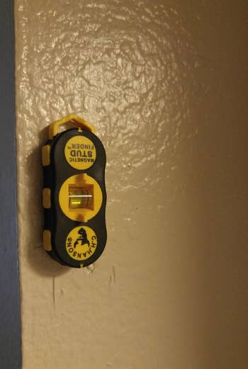 a stud finder stuck to a wall
