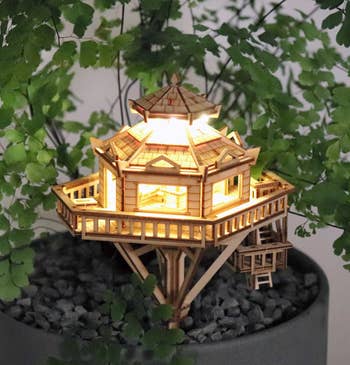 the same wooden model house illuminated from within 