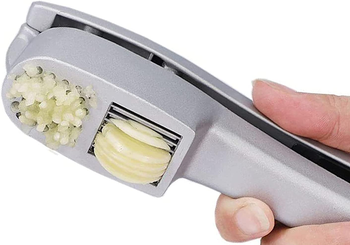 hand pressing garlic through the slicer and mincer simultaneously