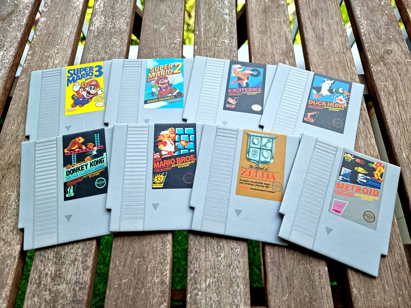a reviewer photo of eight coasters shaped like NES cartridges of different games 