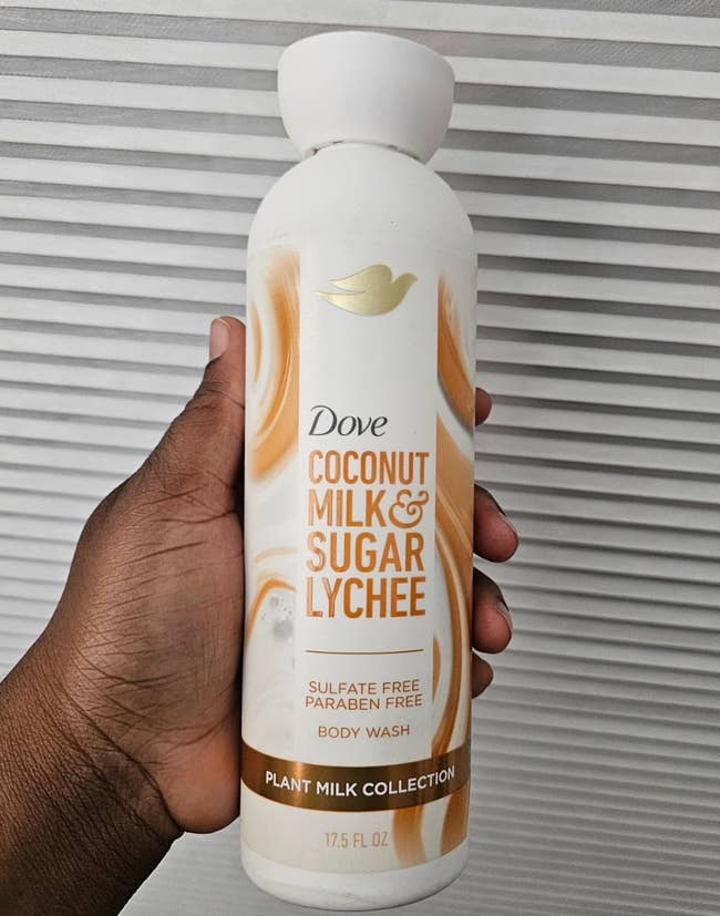 Hand holding Dove Coconut Milk & Sugar Lychee assemblage lavation bottle, sulfate and paraben-free, 17.5 fl oz, from the Plant Milk Collection