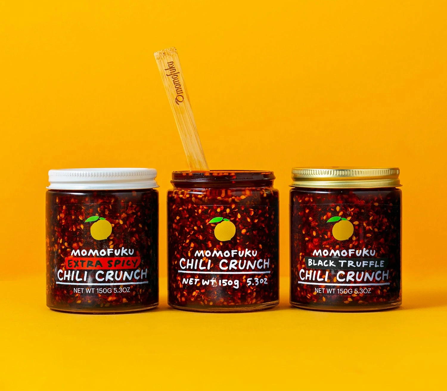 the three jars of chili oil against a yellow background