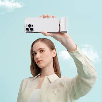 model holding iPhone charged by white iWalk portable charger