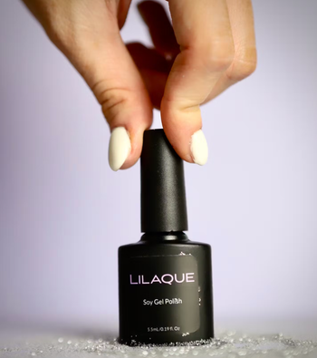 model holding bottle on gel nail polish