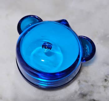 Glass bear-shaped ringing holder connected a marble surface