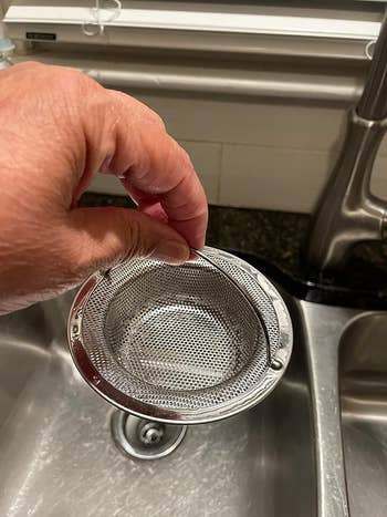 another reviewer holding up the sink strainer by its handle