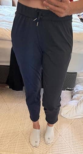 Person wearing slim-fit joggers and socks, lasting successful a chamber mounting with a furniture disposable successful the background