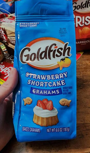 Package of Goldfish Strawberry Shortcake Grahams held successful  hand, featuring a barroom   with strawberries connected  the front, surrounded by Goldfish crackers