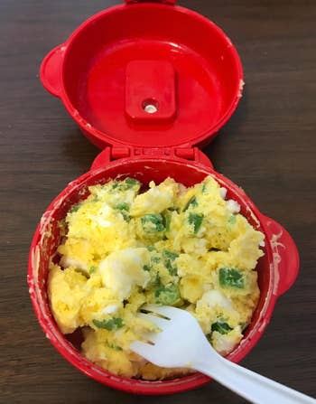 a reviewer eating scrambled eggs with chives out of the cooker