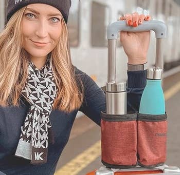Model next to a suitcase with the cup holder attached to its handle