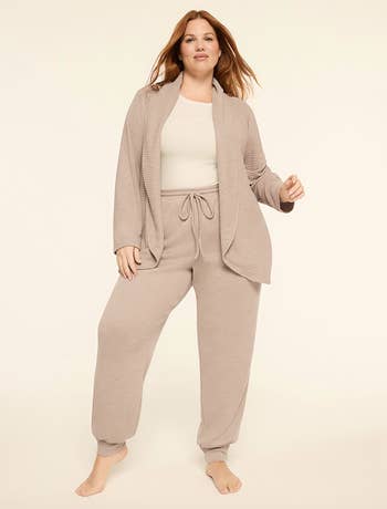 Person wearing a cozy, casual knit loungewear set, consisting of a escaped   cardigan and drawstring pants; paired with a elemental  top