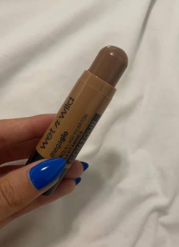 Reviewer holding a tube of Wet n Wild Makeup Stick for contouring