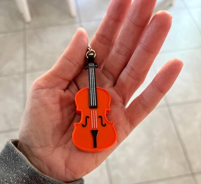 Hand holding an violin-shaped keychain