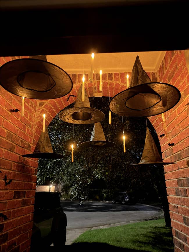 Floating witch hats and candle lights bent nether a porch, creating a spooky entrance