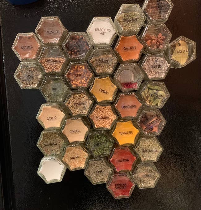 reviewer's glass magnetic spice jars with labels on side of fridge