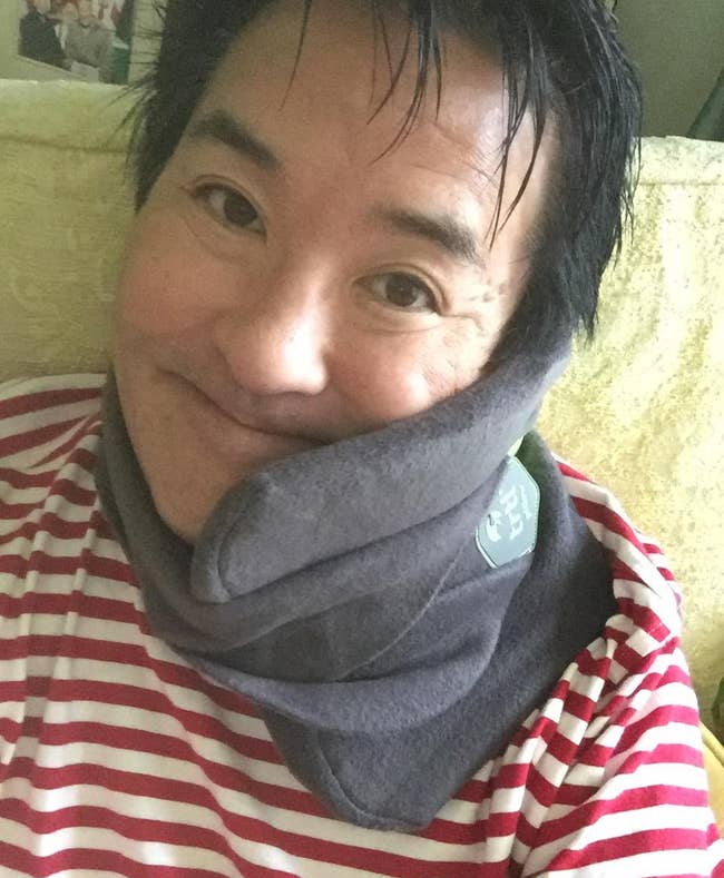 a reviewer wearing the travel pillow around their neck 