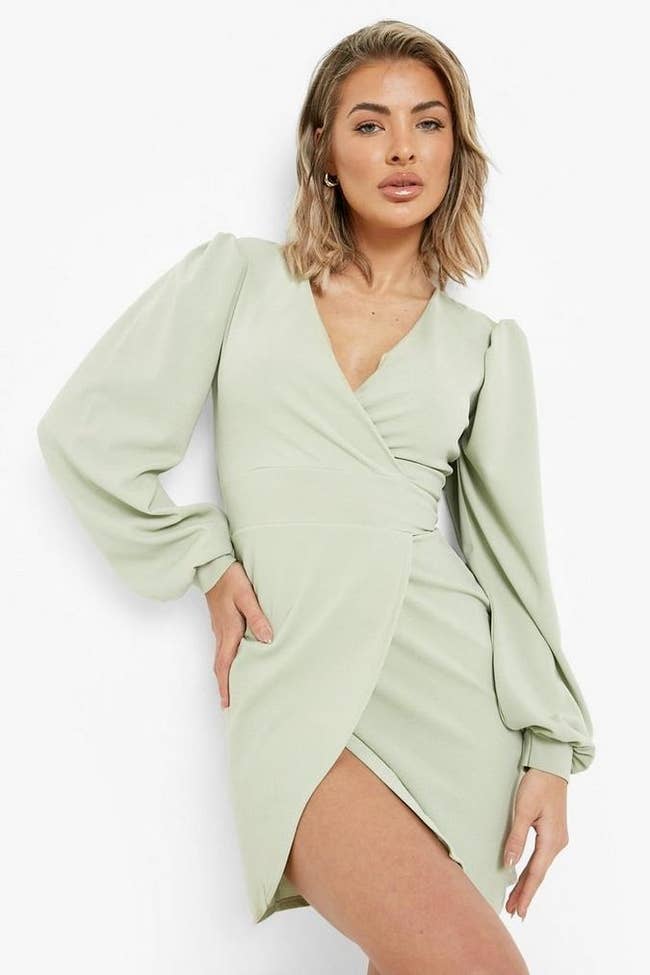 model posing in mint green wrap mini dress