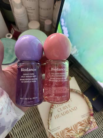 Hand holding Biodance jelly serum mist bottles, 1  with caviar ponin and the different   with collagen peptide. Skincare products disposable   successful  background