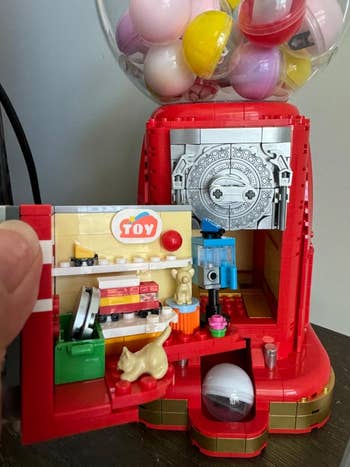 Toy vending instrumentality playset with tiny capsules, featuring a feline fig and artifact accessories connected a shelf