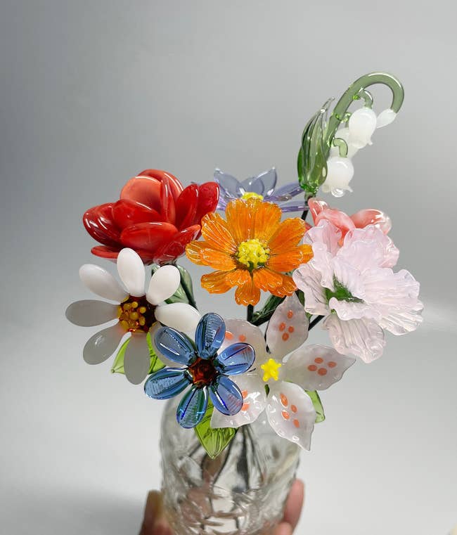Glass vase with intricately crafted solid flowers