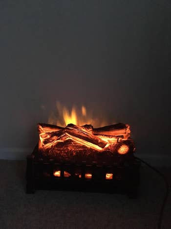 Electric fireplace insert with glowing artificial logs