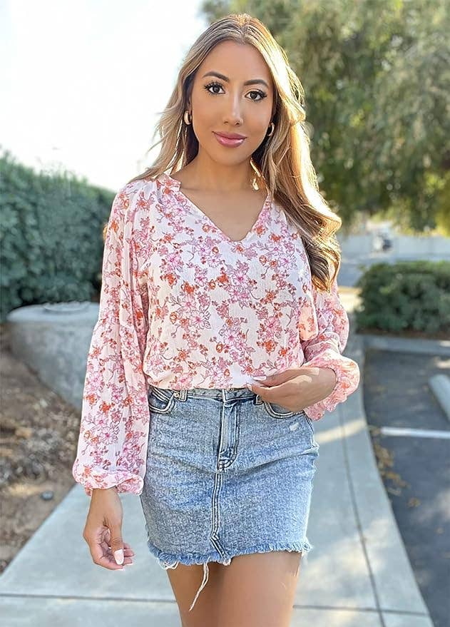 person in a floral blouse and denim skirt posing 