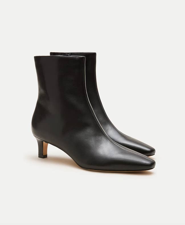 Black leather ankle boots with kitten heels, featuring a sleek pointed toed design