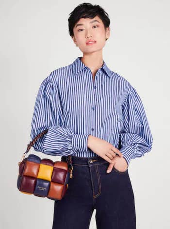 model holding the color block bag in purple, yellow, orange, and blue 
