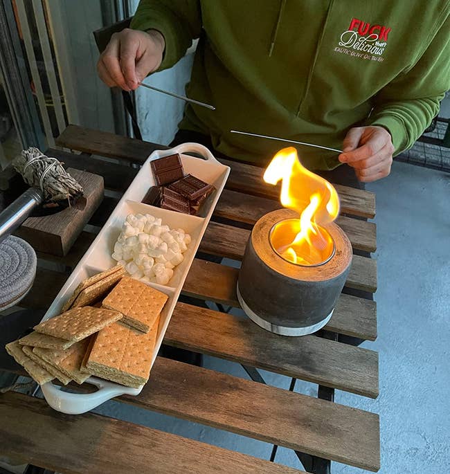 smores setup with small fire pit on a bistro patio table