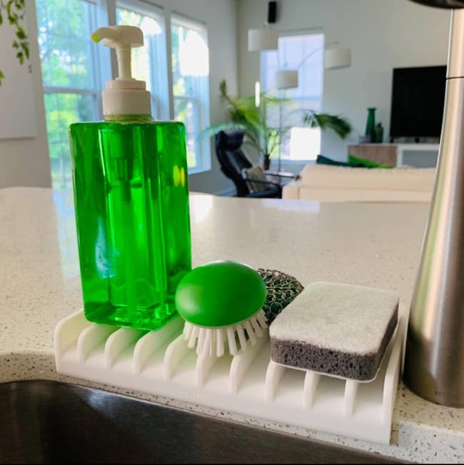 Green soap dispenser, scrub brush, and sponge connected  a descend  caddy successful  a modern   room  with earthy  light