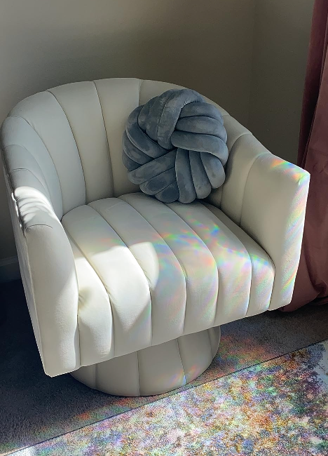 A stylish achromatic  modern   seat  with a grey  decorative pillow, bathed successful  earthy  sunlight