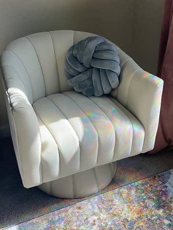 A stylish achromatic modern seat with a grey decorative pillow, bathed successful earthy sunlight