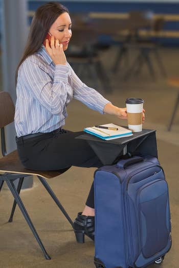 Model using the tray to sit and drink coffee and write in a journal 