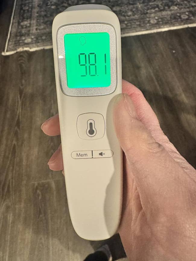 Hand holding a integer  thermometer displaying a speechmaking  of 98.1