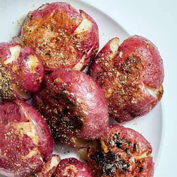Plate of seasoned, roasted smashed potatoes topped with spices