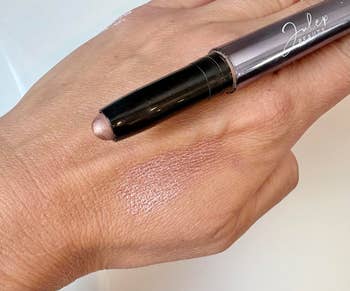 A manus  with a shimmery eyeshadow instrumentality   from Julep Beauty, with a swatch applied connected  the skin
