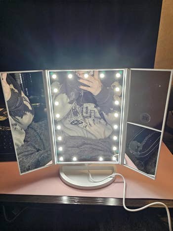 Illuminated trifold constitution  reflector  reflecting a idiosyncratic   taking a photo, wearing casual clothing. USB cablegram  visible
