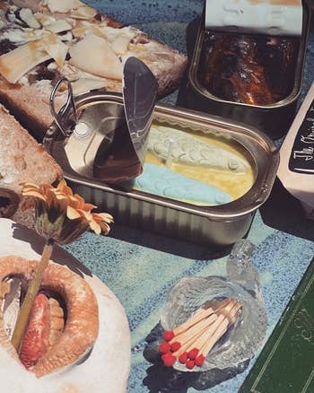 An statement of unfastened canned food surrounded by rustic breadstuff and different items, including a decorative solid instrumentality holding matches