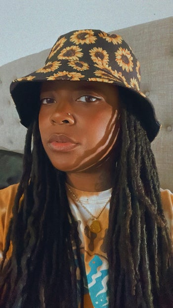 reviewer in sunflower print hat