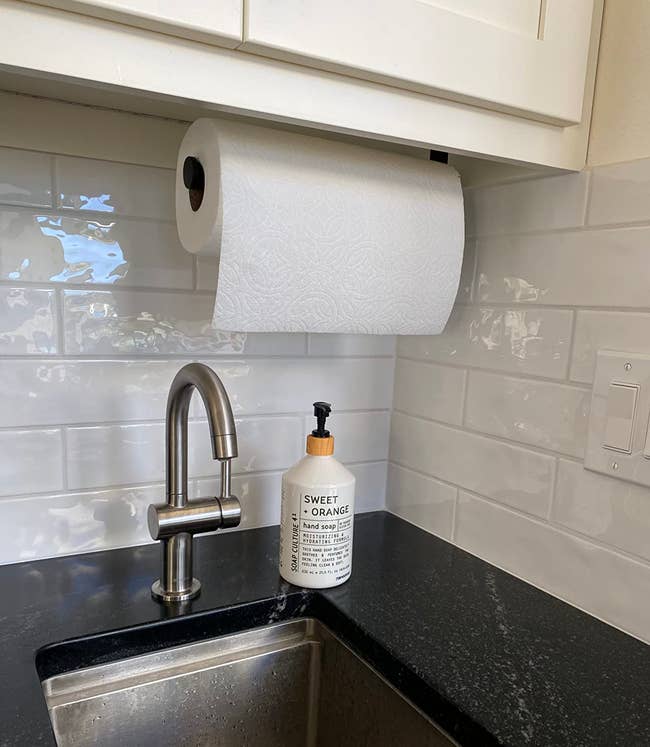 the under cabinet paper towel holder next to a sink