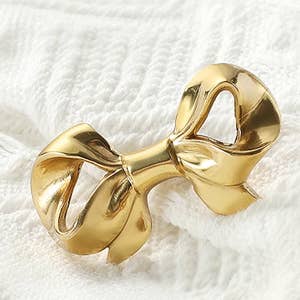 Small gold bow knob on a flat surface 