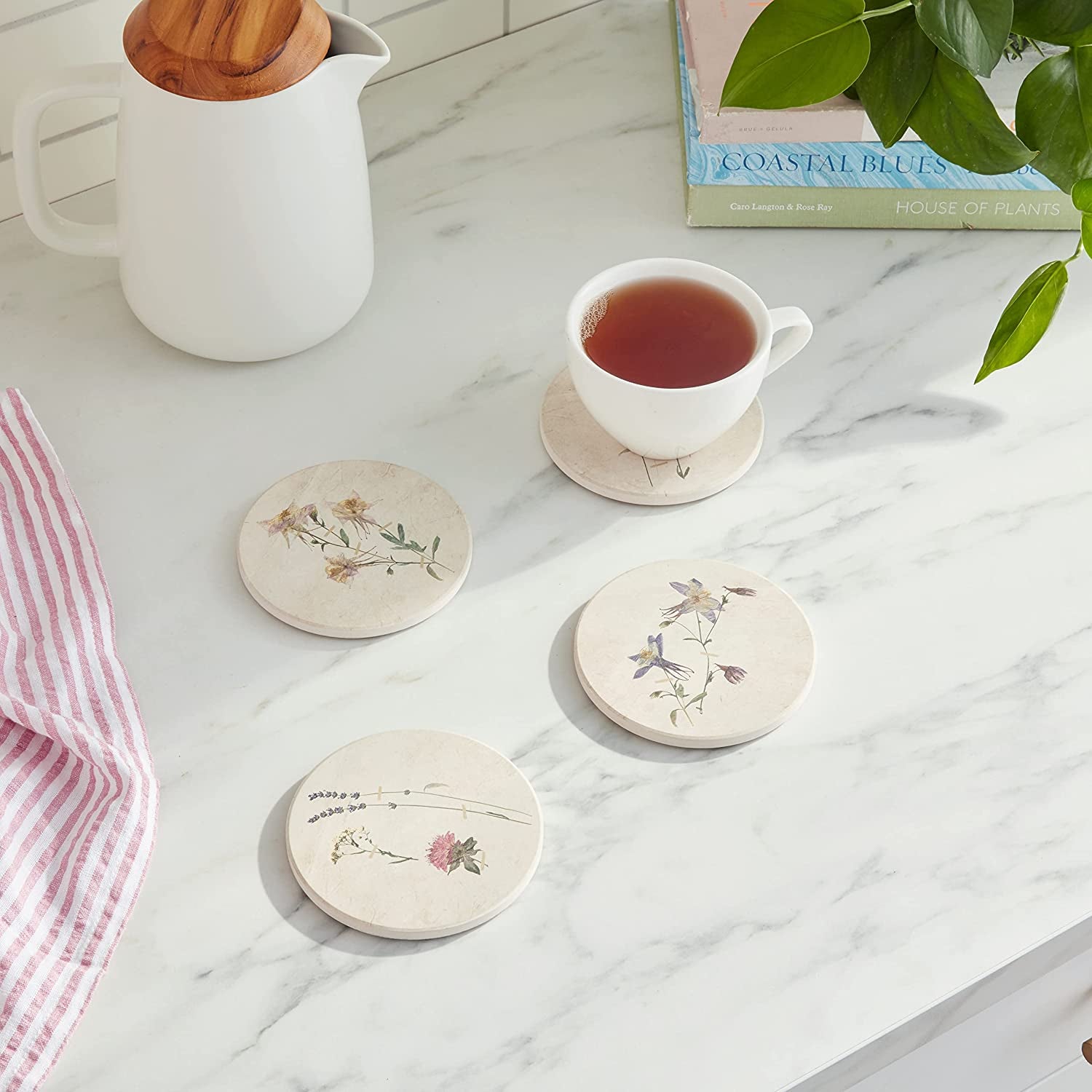 four pressed floral coasters on marble table
