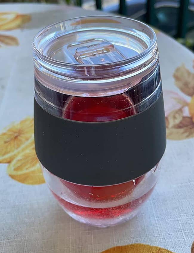 Clear integrative cupful with a achromatic set contains a reddish drink