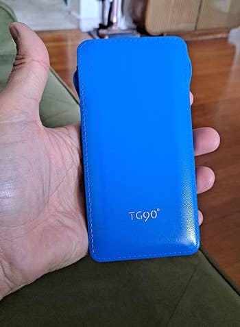 reviewer holding blue power bank